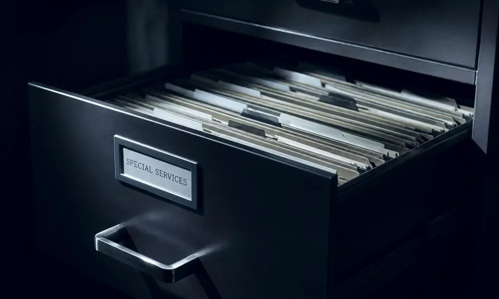 Half-open filing drawer filled with folders in shadow.