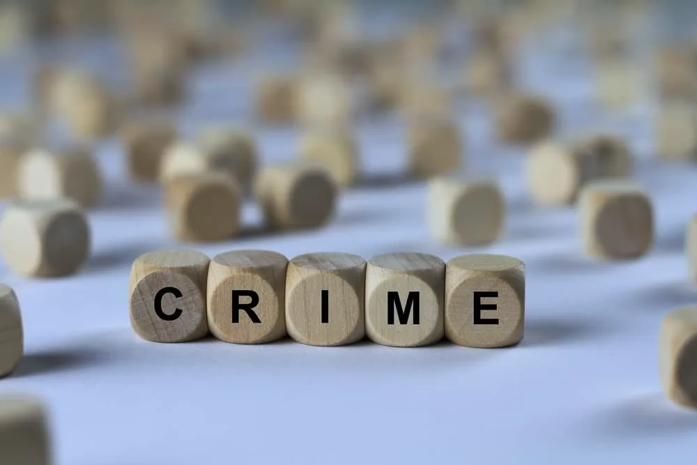 Wooden cubes arranged to spell the word 'crime,' representing the concept of crime in a symbolic manner.